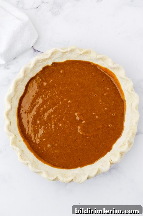 Pumpkin pie filling poured into an unbaked pie shell