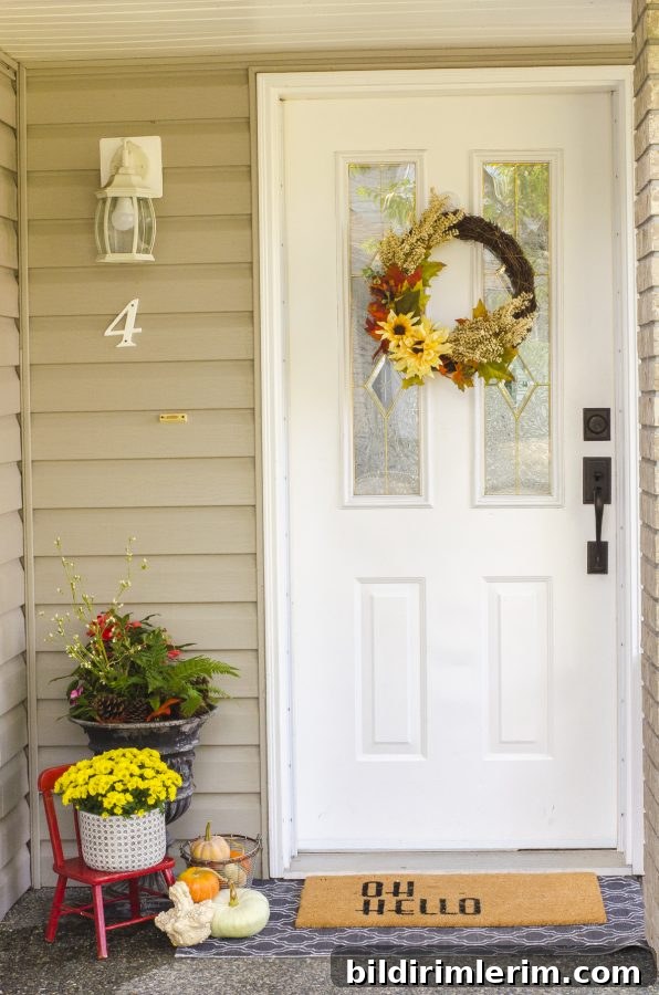 Fall mums in a pot beside a front door.