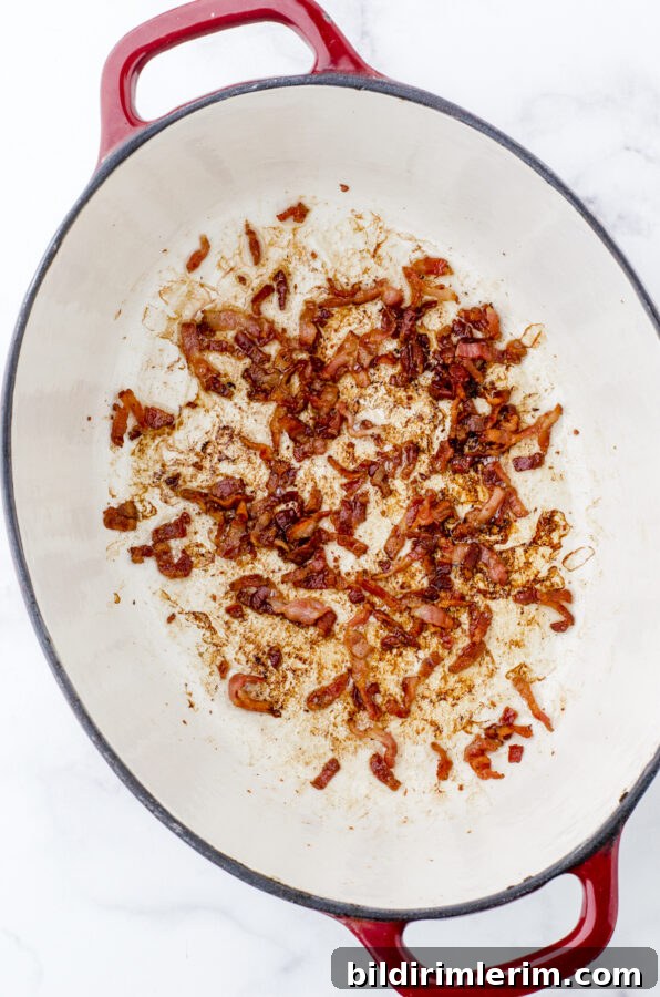 Crispy bacon in the bottom of an enamel cast iron dutch oven.