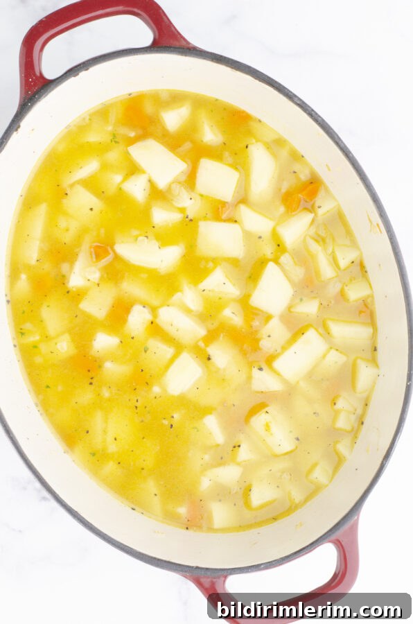 Potato soup ingredients all in a large dutch oven.