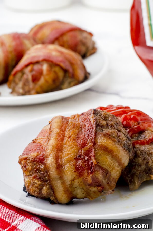 Bacon wrapped meatloaf on a plate ready to be eaten with a drizzle of ketchup on top.