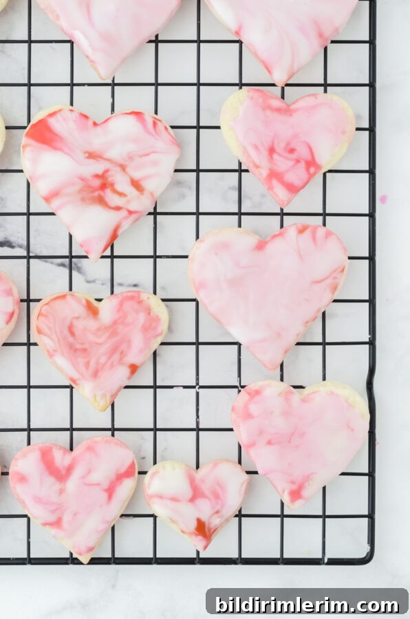 heart cookies on a cooling rack with buttercream marble icing