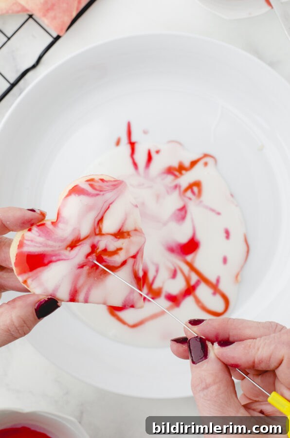 using a metal cake tester to swirl the colors onto the cookie