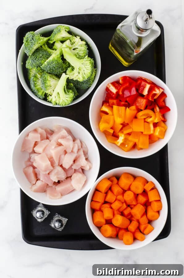 Ingredients for sheet pan chicken and veggies with broccoli, peppers, and carrots.
