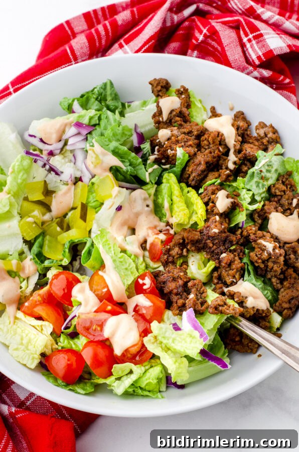 Big Mac Salad Recipe: Copycat Burger Bowl with Special Sauce 4 A healthy big mac salad bowl with special sauce drizzled on top in a bowl ready to eat.