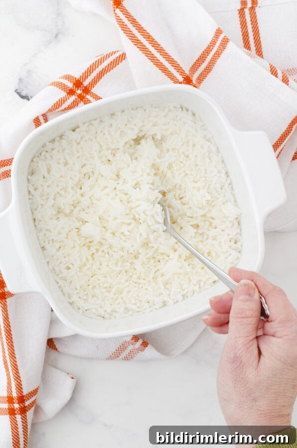 A person fluffing oven baked rice with a fork