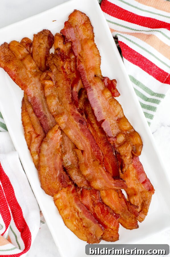 How to Make Crispy Bacon in the Oven Every Time 9 Crispy bacon in a long and skinny white serving platter.