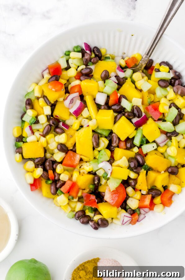 Mango salad ingredients stirred together in a bowl.