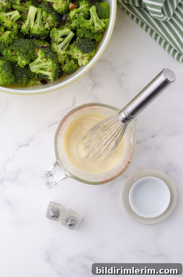 Classic Broccoli Salad with Cranberries Recipe 5 The miracle whip dressing being whisked in a bowl for broccoli salad with cranberries
