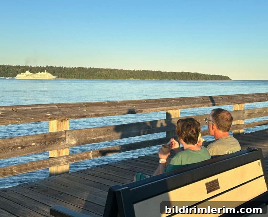 man and woman on a park bench eating icing cream with wooden spoons watching a cruise ship go by