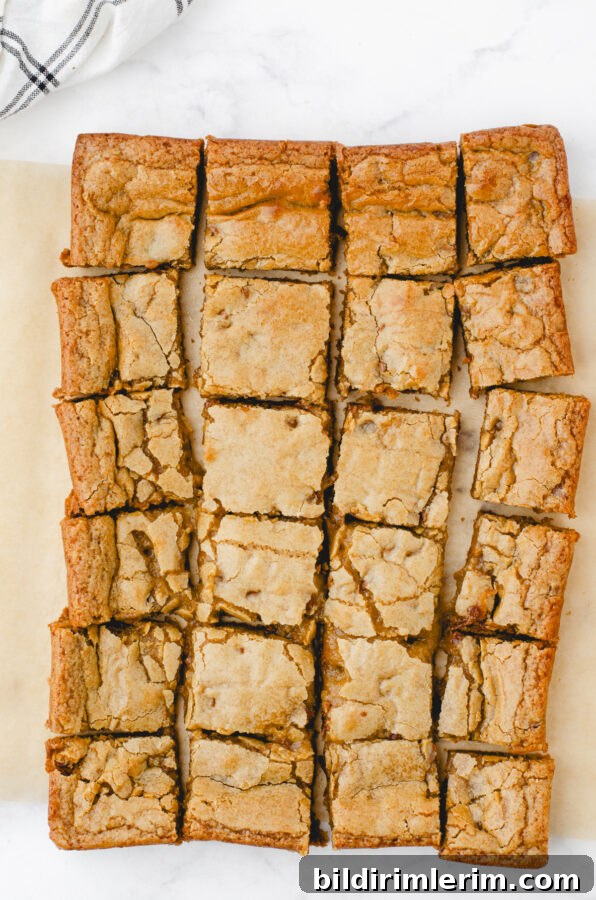 Soft, Chewy Butterscotch Blondies Recipe 9 butterscotch brownies cut into squares on top of a piece of parchment paper