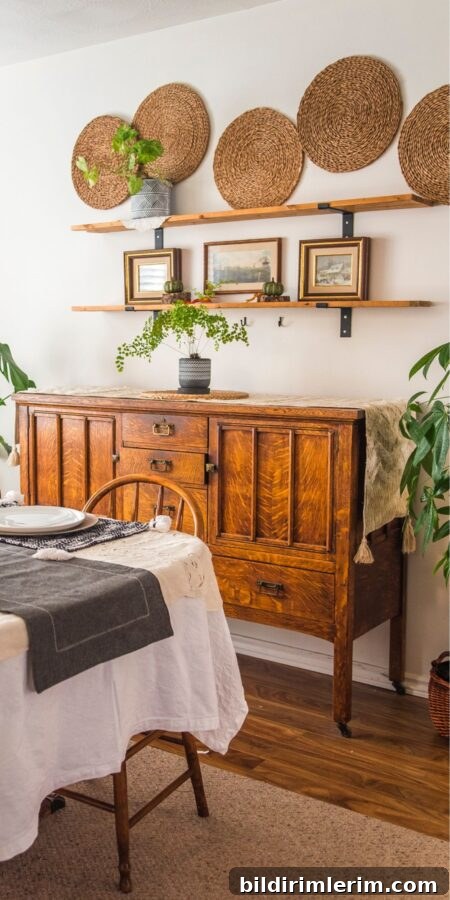 Antique buffet with farmhouse shelves above it decorated with boho style fall decor