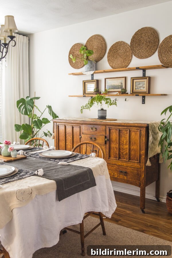plants around an antique buffet with farmhouse shelves above it with vintage pictures and plants on the shelf