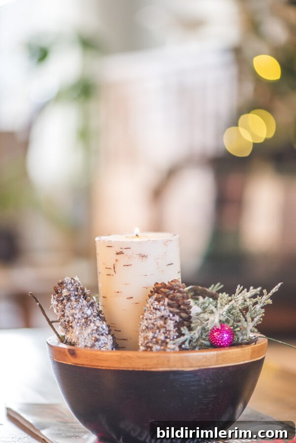 a wooden bowl with a candle and pine cones around it