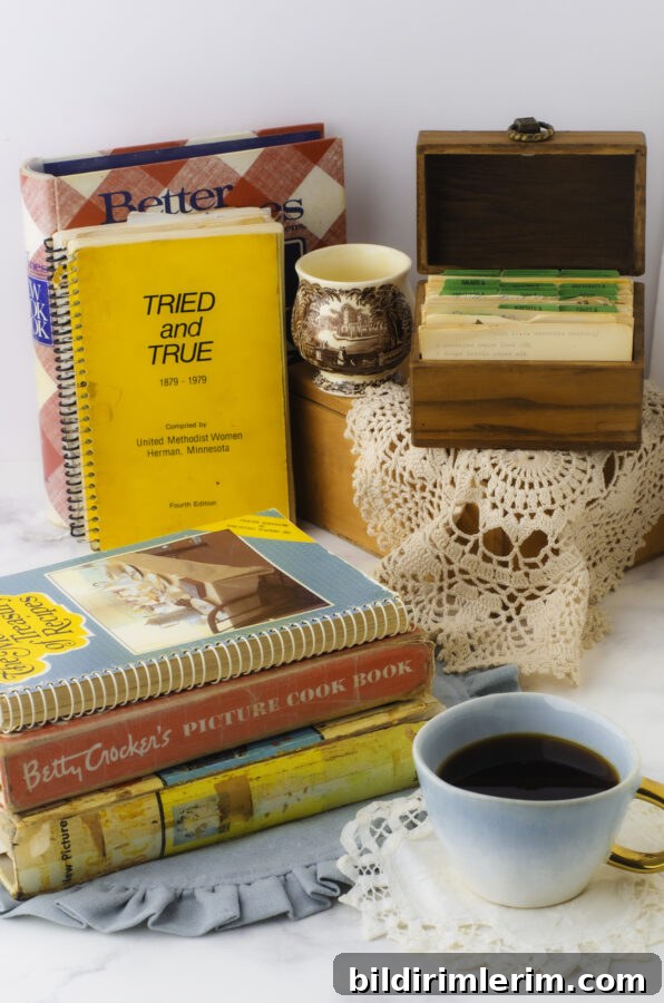 Collection of the best vintage cookbooks stacked up with old recipe cards beside them.