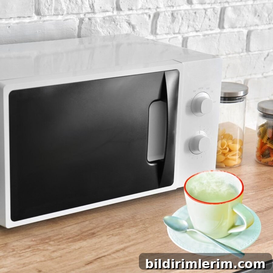 How to Boil Water in the Microwave Without Superheating 2 A microwave with a cup of steaming water sitting in front of it.