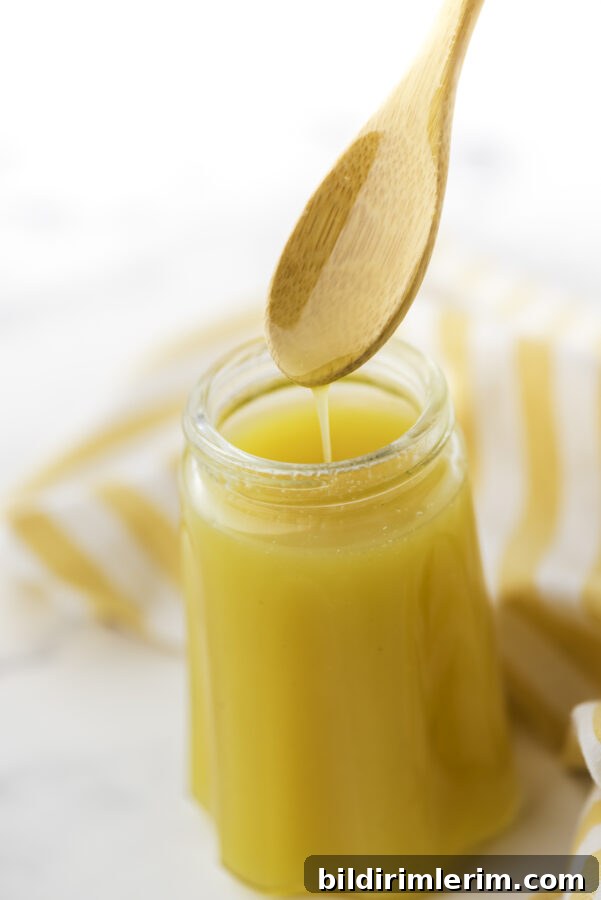 Grandma's Classic Mustard Sauce Recipe for Holiday Ham 2 Warm mustard sauce for ham drizzling from a spoon