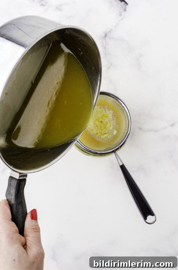 Mustard sauce for ham being strained with a small mesh strainer