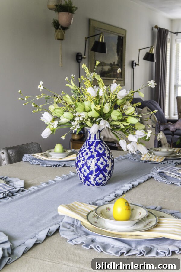 A ginger jar vase flower arrangment on a table that is set for Easter.