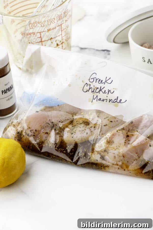 Greek Lemon-Oregano Chicken Marinade for Grilling 2 Greek chicken marinade recipe poured over chicken in a ziploc bag and marked with a sharpie marker on the front saying "Greek Chicken Marinade".