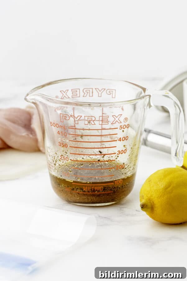 Greek Lemon-Oregano Chicken Marinade for Grilling 3 Greek chicken marinade ingredients whisked together in a large measuring cup.