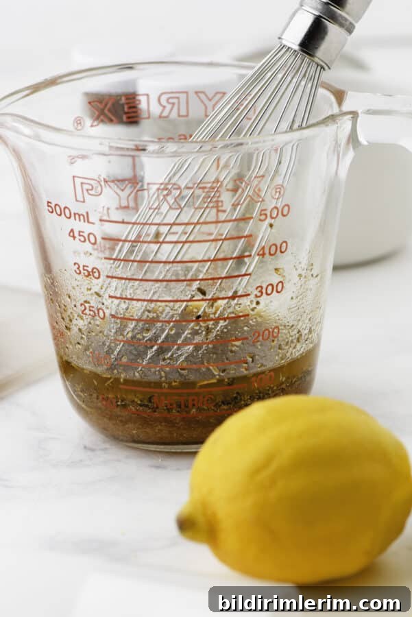 Greek Lemon-Oregano Chicken Marinade for Grilling 4 A whisk in the container of greek chicken marinade.