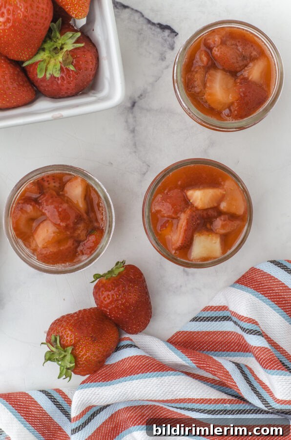 Three small jars of strawberry sauce