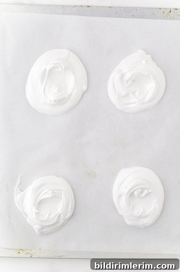 Individual pavlovas piped into bowls on a baking sheet