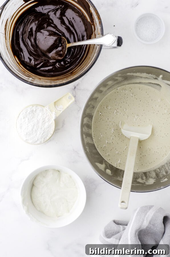 Soft, Fudgy Sourdough Discard Brownie Recipe 4 A microwave safe bowl with the chocolate mixture melted and stirred until smooth, and the bowl of a stand mixer with a mixture of beaten eggs and sugar.