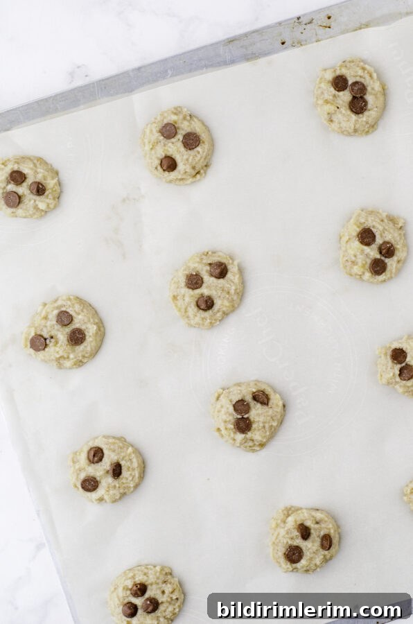 Mini Banana Bread Cookie Bites Recipe 6 Banana Cookies dough scooped out and on a cookie sheet with chocolate chips in the top.