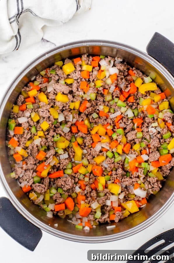 Classic Italian Minestrone Soup Recipe 4 A large stock pot with browned ground beef and veggies as the base for minestrone soup.