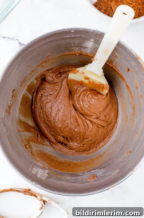 Chocolate pudding cake batter in the bowl of a stand mixer.
