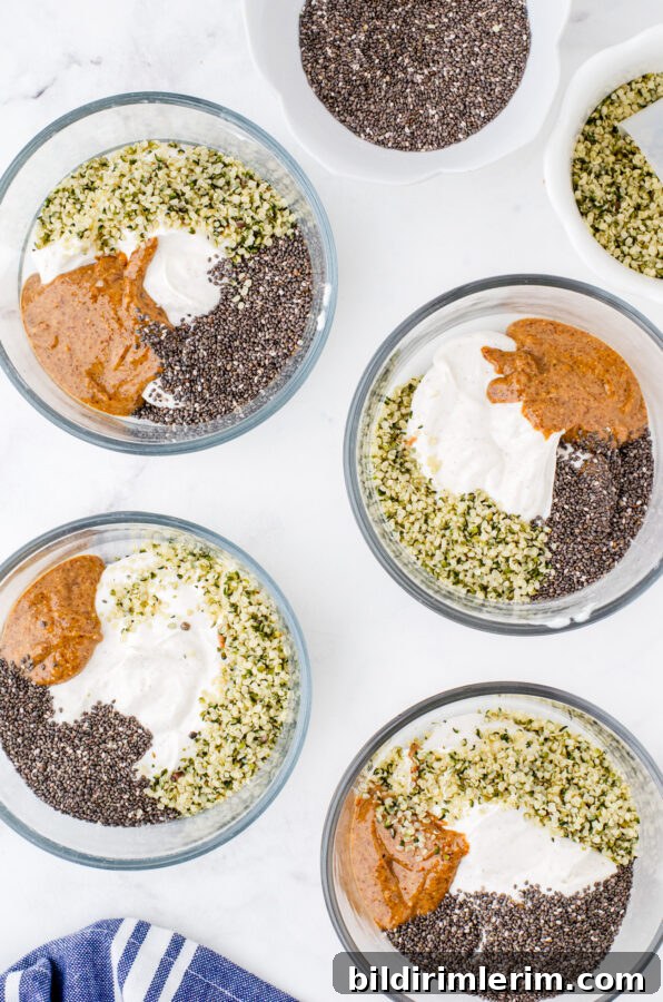 Make-Ahead Yogurt Bowls for Quick Grab-and-Go Breakfasts 6 4 clear glass bowls with greek yogurt, almond butter, chia seeds, and hemp seeds in each one.