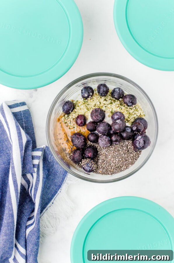 Make-Ahead Yogurt Bowls for Quick Grab-and-Go Breakfasts 8 A yogurt bowl assembled with berries on the top and other yogurt bowls with lids surrounding it.