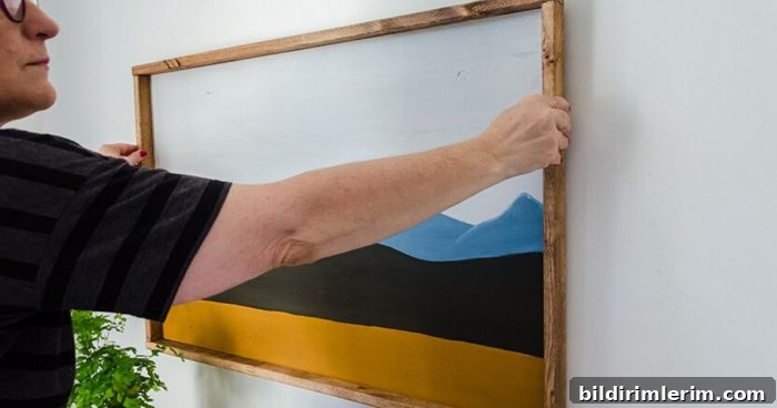 How to Hang Wall Decor: Tips and Practical Hacks 4 Woman hanging a big picture on the wall
