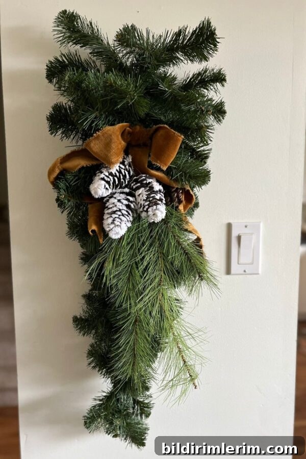 Finished upcycled Christmas swag with velvet bow and pine cone picks