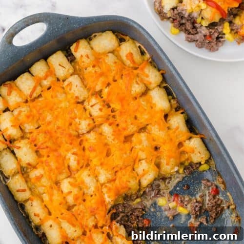 Pan of tater tot casserole with a serving removed from it