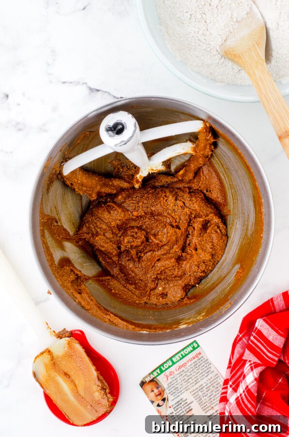 The creamed butter, sugar, and molasses in a mixing bowl for chewy gingersnaps recipe.