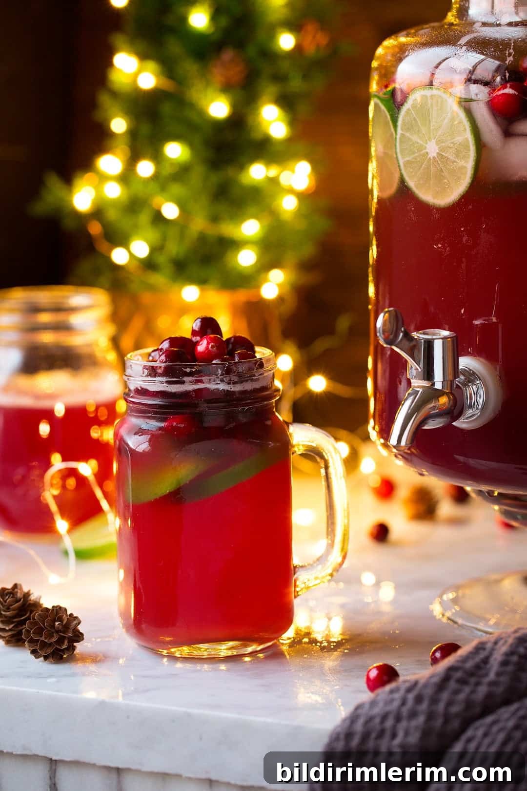 Festive Non-Alcoholic Punch Recipes for Holidays and Parties 7 Glass of Christmas punch beside a large dispenser with punch in it.