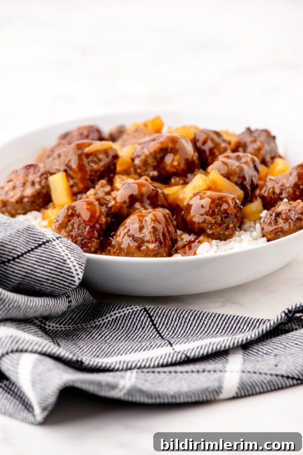 Waikiki Sweet and Sour Meatball Recipe with Pineapple Tidbits 7 Bowl of sweet and sour meatballs with pineapple tidbits over a bed of rice.