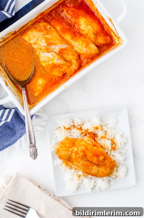 A pan of apricot chicken breasts with a serving on a bed of rice beside it.