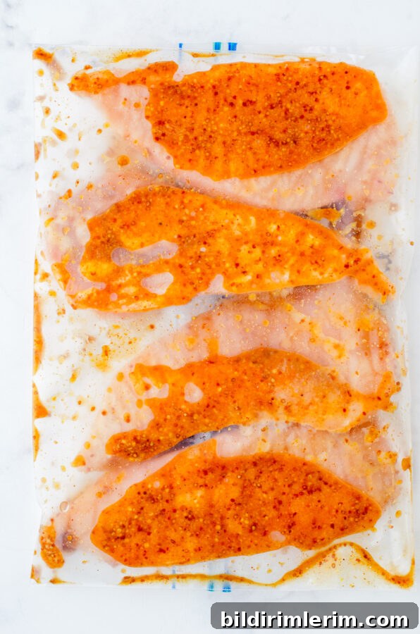 Chicken covered in marinade in a bag.