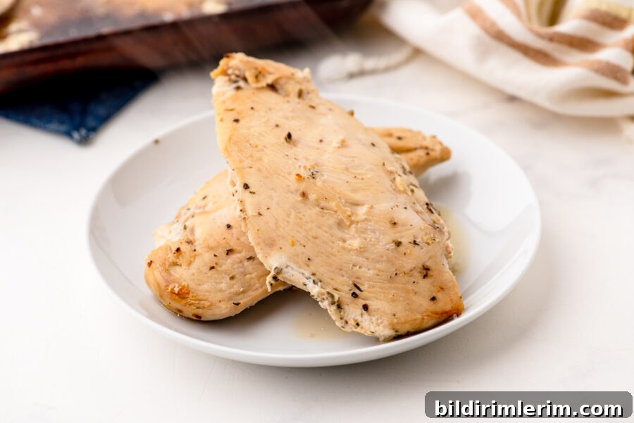 2 pieces of lemon chicken baked and on a serving plate - steaming from the heat.