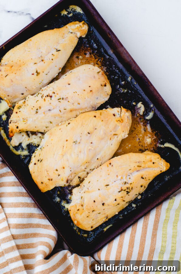 4 chicken breasts that have been marinaded in lemon chicken marinade baked in a stoneware baking pan.
