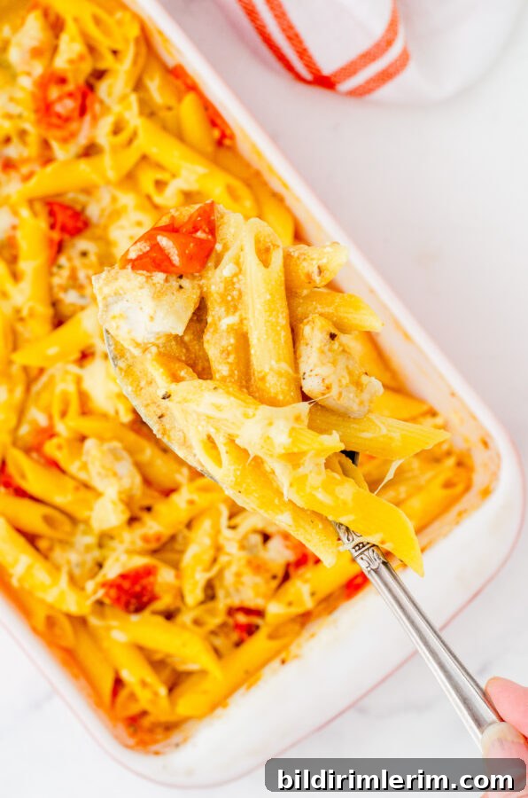 Serving spoon scooping feta chicken pasta