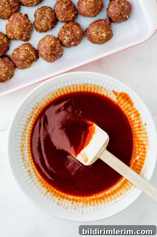 Homemade barbecue sauce for meatballs stirred in a bowl.