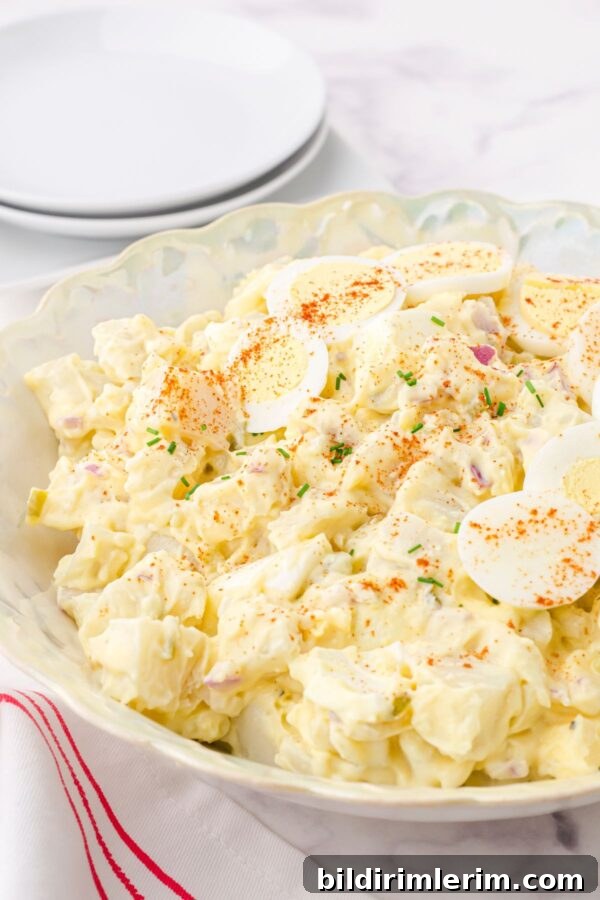 A serving dish full of classic potato salad with egg