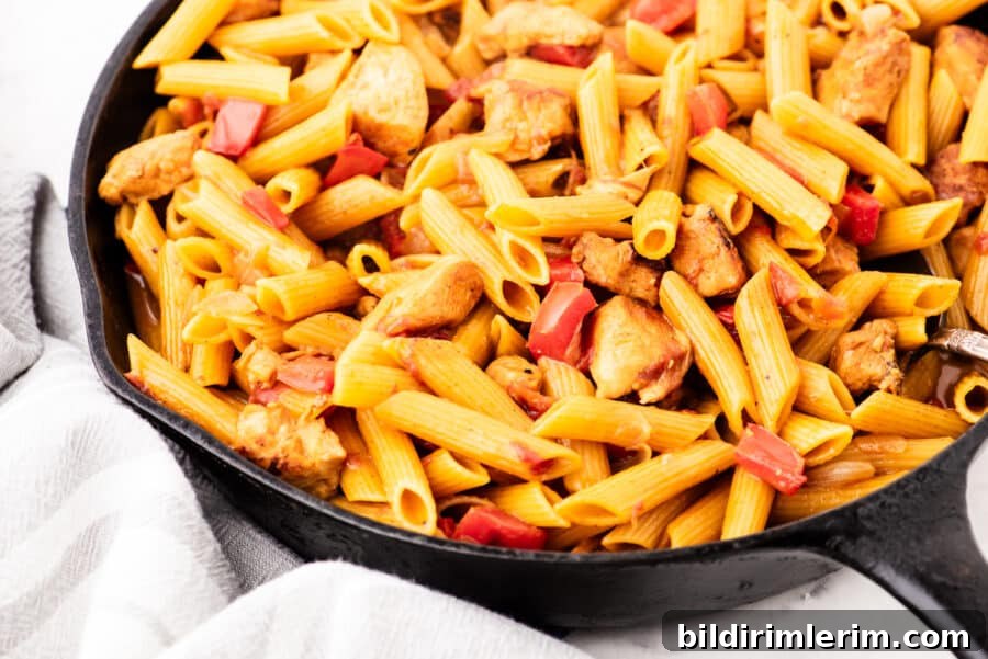 A cast iron skillet with one pot chicken pasta in it.