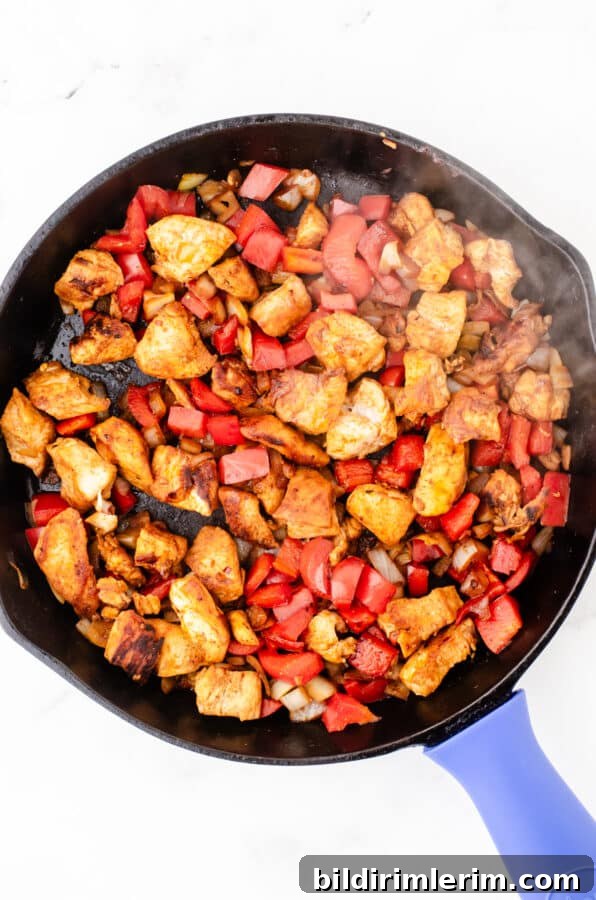 Sauted chicken and veggies in cast iron pan for one pot chicken pasta