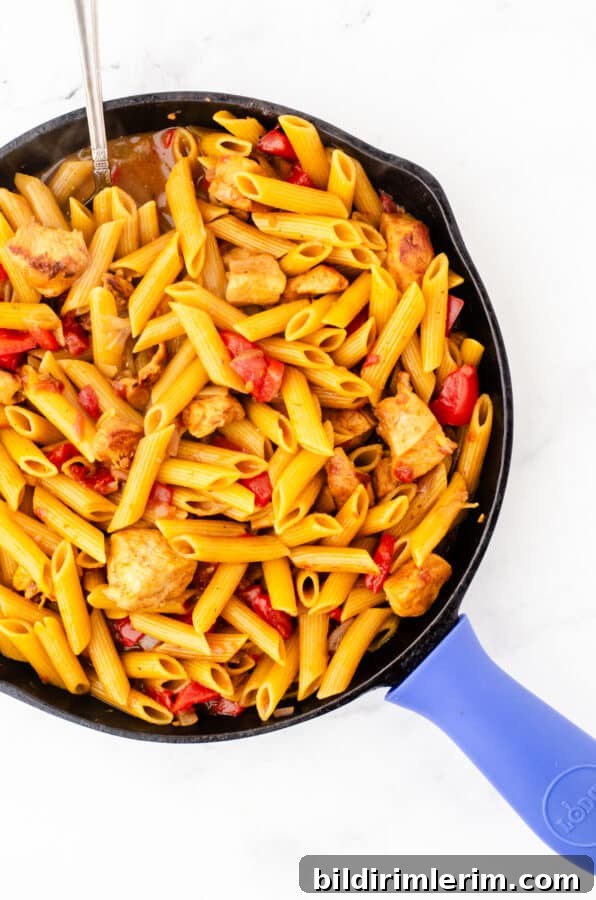 One pot chicken pasta in a skillet after the penne is cooked and the milk has been added.